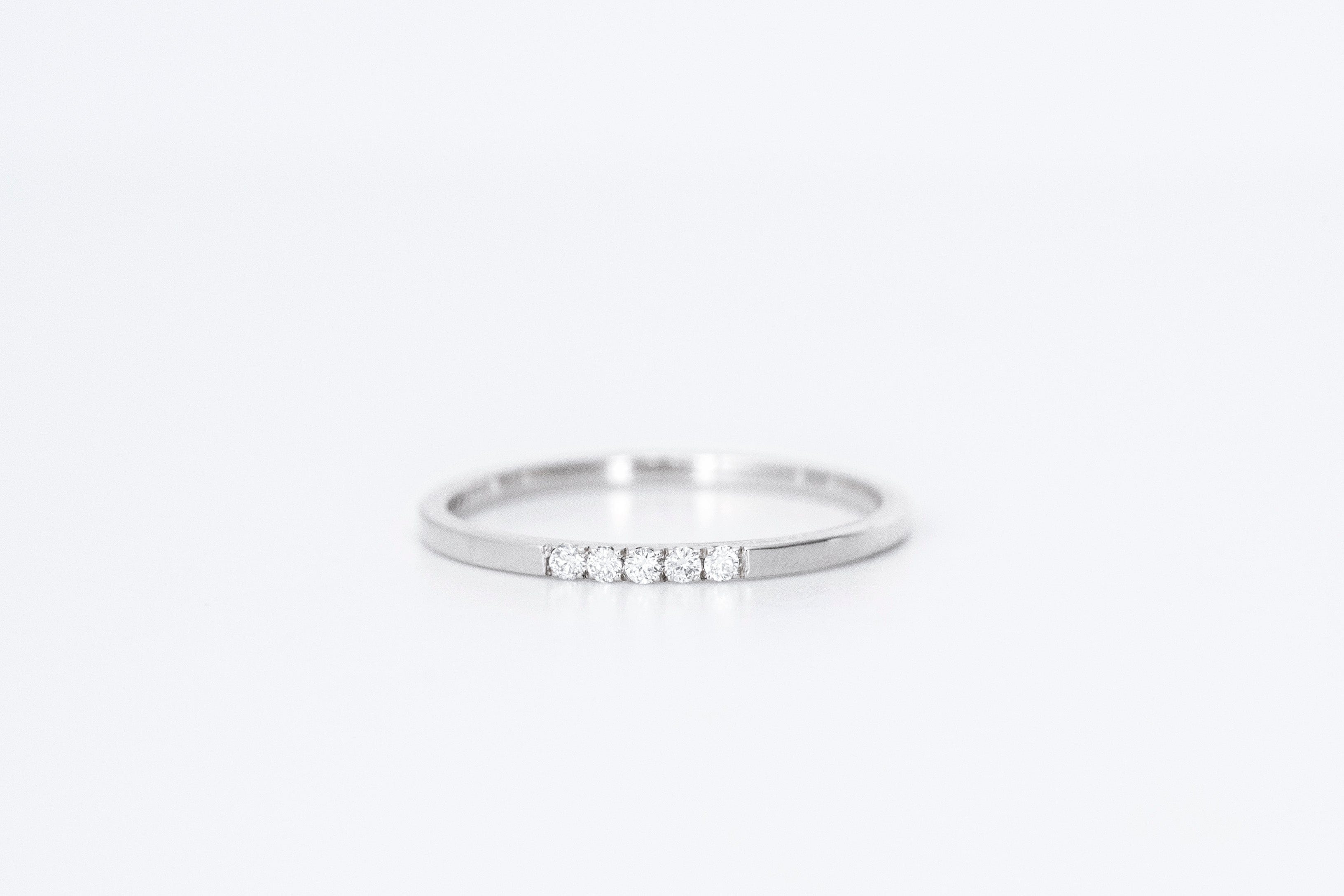 thin diamond wedding band with 5 small diamonds in white gold